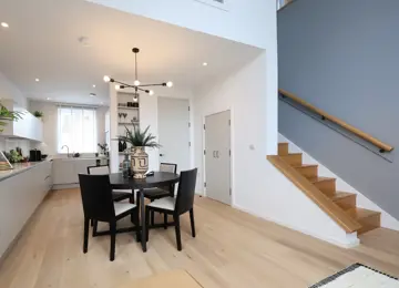 Open-plan kitchen diner, with views of the engineered wood flooring leading upstairs.