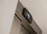 A close up of the apartment lift digital screen with arrows indicating going up a level.