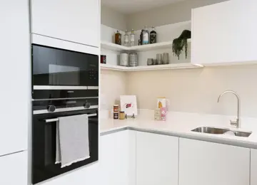 Cosy kitchen corner featuring styled shelving.