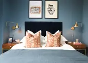 Styled double guest bedroom with matching bedside tables and a warm blue theme.