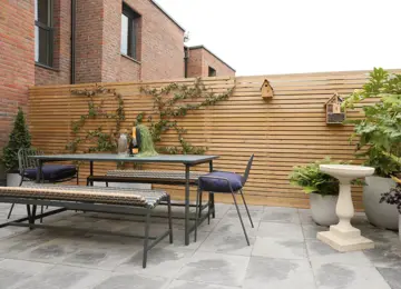 New build courtyard garden, featured slat fencing, stylish furniture and fence climbing plants.