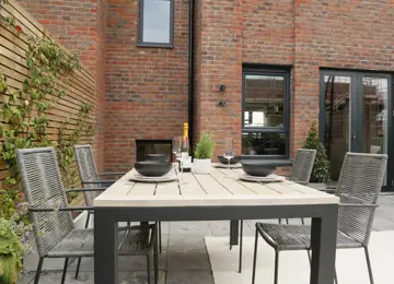 Courtyard garden, featured slat fencing, styled outdoor dining table and fence climbing plants.