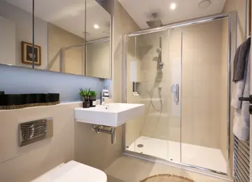 Stylish shower room with dark style details and fluffy grey towels perfectly placed on the towel warmer.