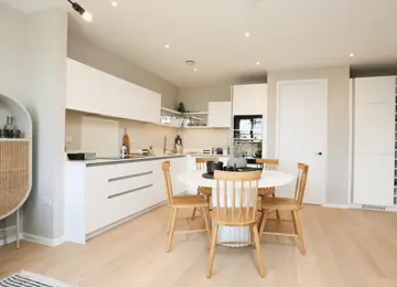 Stylish open-plan kitchen diner, featuring open shelving and integrated appliances.