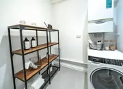 Utility room including the boiler and washing machine, featuring styled shelving.