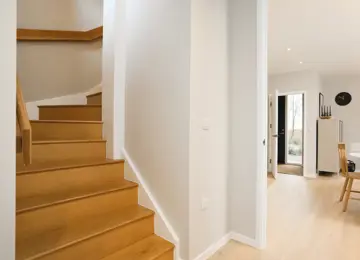 Hallway wide angle shot featuring the engineered wood flooring leading into the open-plan dining room.