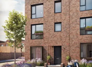 Three-storey red-brick townhome with a flat roof, large windows and intricate brickwork detailing the front.