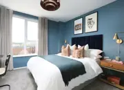 Deep blue decor and wood accents compliment the apartment double guest bedroom.