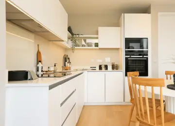 Open-plan kitchen diner with stylish white work tops and added extras.