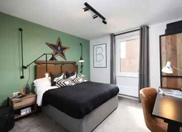 Teenage double bedroom featuring moody styling, a work desk and green feature wall.