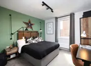 Teenage double bedroom featuring moody styling, a work desk and green feature wall.