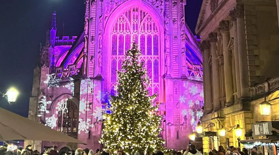 Pictured is Bath Abbey featuring charming cobbled streets and a decorative Christmas tree.