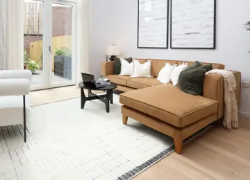 This living room is flooded with natural light featuring a beige corner sofa and cosy furnishings.