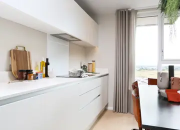 Close up image displaying kitchen essentials displayed on white glossy worktops.