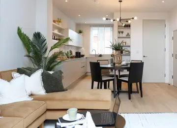 Open-plan living room and kitchen diner flooded with natural light leading in from double height patio doors.