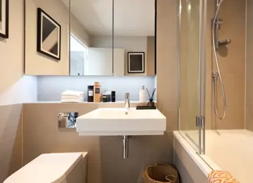 Stylish family bathroom with added extras such as fluffy white towels and woven baskets.