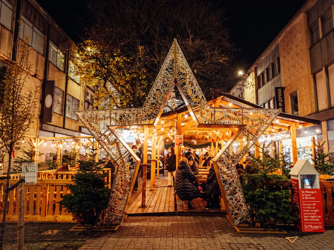 People enjoying mulled wine in a traditional pop-up bar at Bristol Christmas market